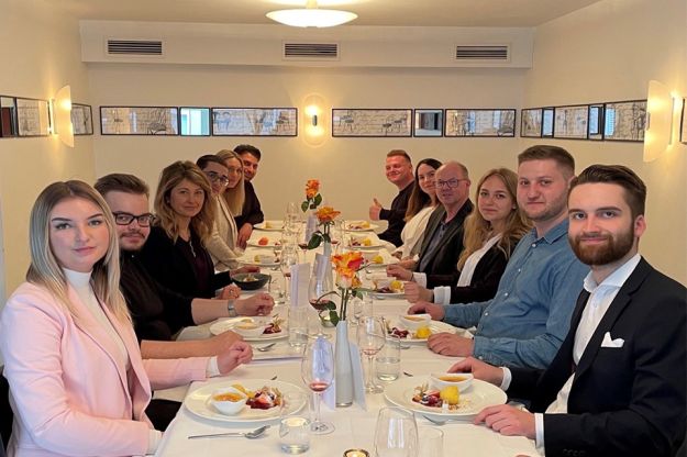 Schicke,junge Menschen am festlich gedeckten Tisch.